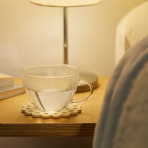 Verre d’eau chaude fumante, rappel de l’importance de l’hydratation en hiver pour éviter la peau sèche